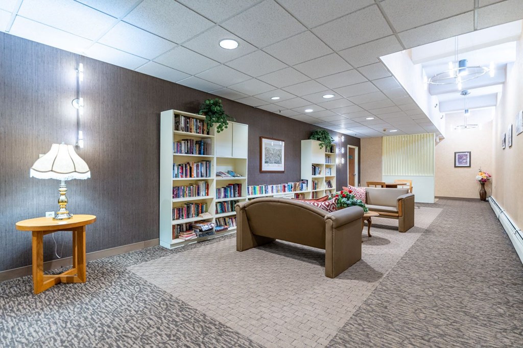 a library with a couch and chairs and shelves of books