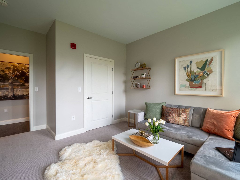 A secondary lounge or study area with a loveseat, coffee table, and tasteful artwork on the walls.