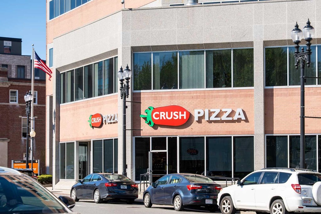 A Crush Pizza restaurant with cars parked in front.