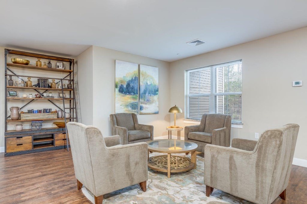 A comfortable lounge with armchairs and side tables, inviting residents to relax and chat at Webster Woods.