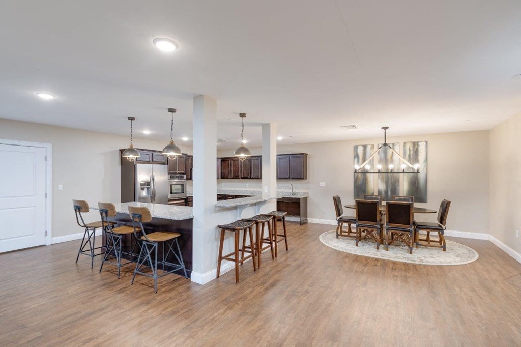 A communal dining and lounge space with tables, chairs, and modern lighting, reflecting Webster Woods’ shared spaces.