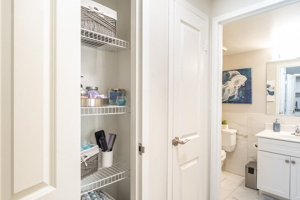 a small bathroom with white cabinets and a white door