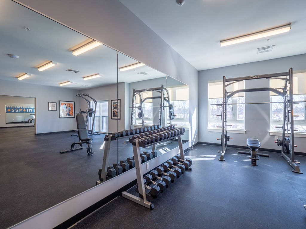 A well-appointed fitness center featuring free weights and strength training equipment.