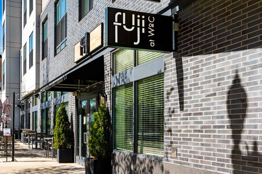 A black and white sign that says Fuji on WoC on a building in Quincy, MA.