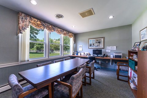 A conference room with a long table and chairs.
