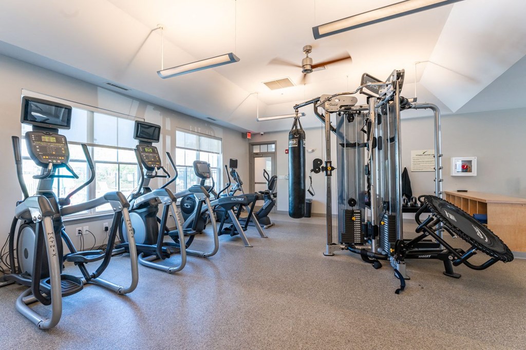 a fitness room with exercise equipment and windows
