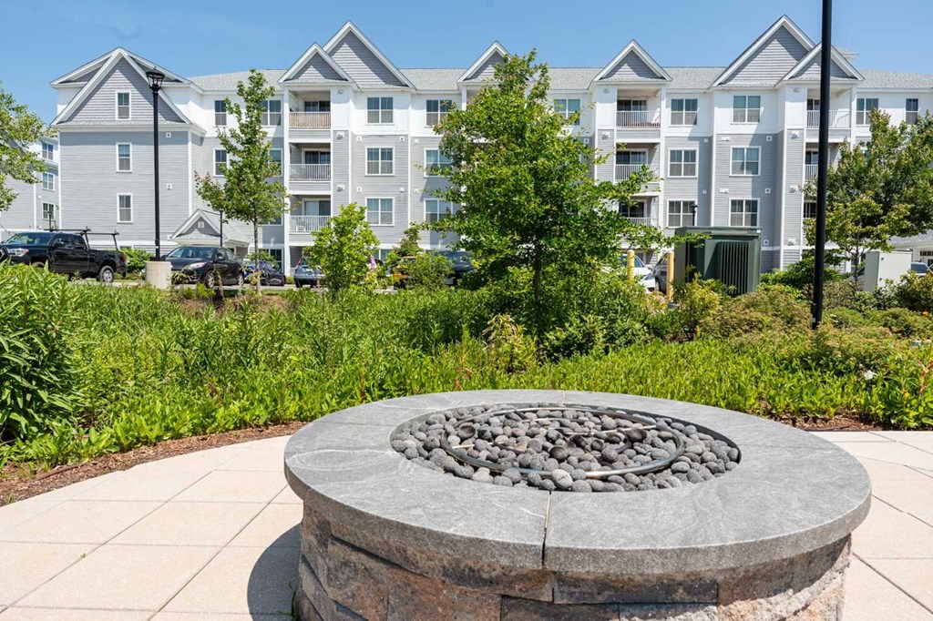 a stone fire pit in front of an apartment building