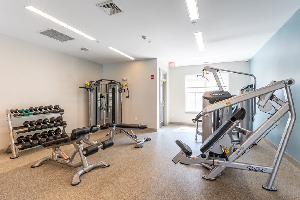 a gym with weights and dumbbells in the corner of a room