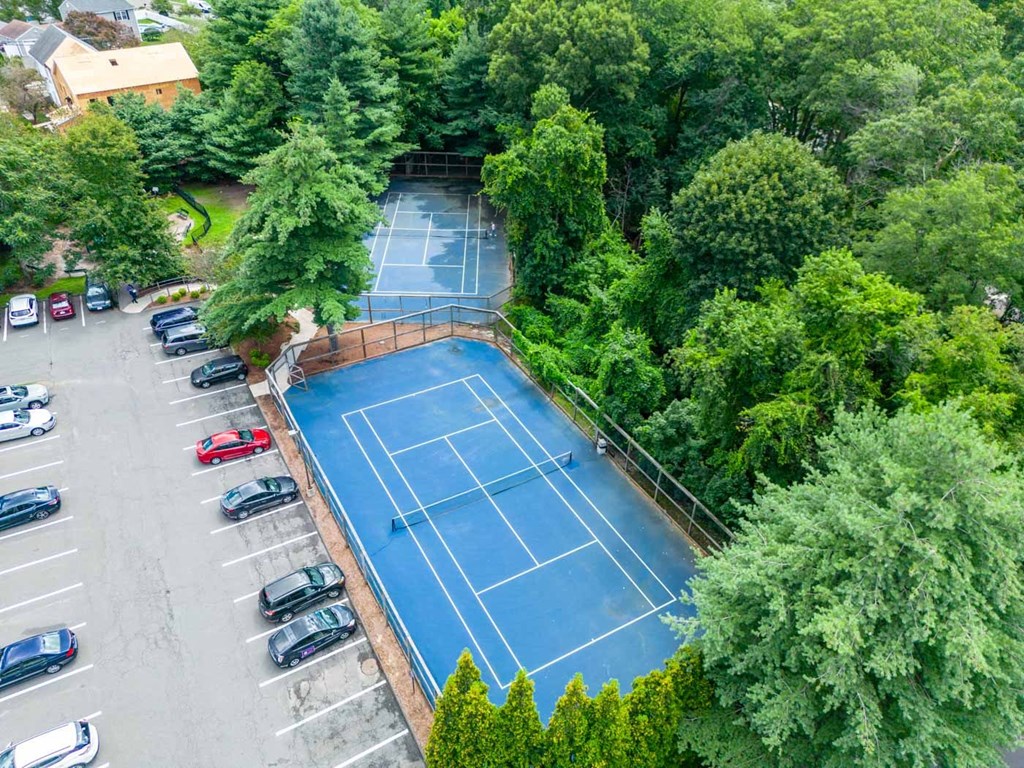 an aerial view of a tennis court and parking lot