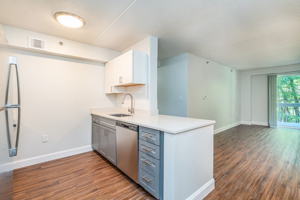 an empty kitchen with a counter top and a stainless steel refrigerator