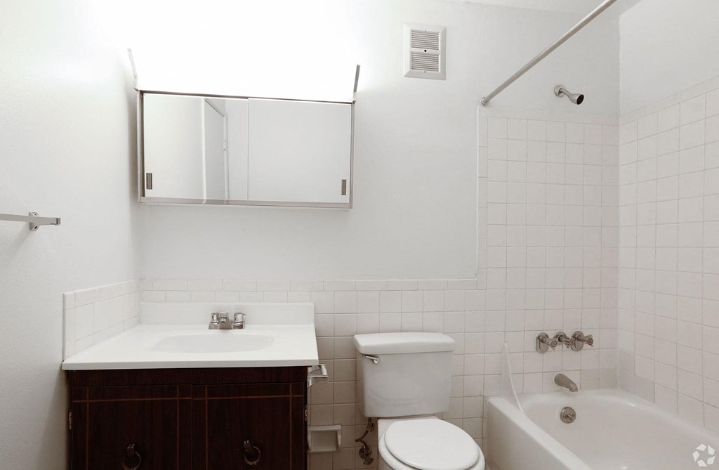 A white bathroom with a toilet, sink, and bathtub and vanity at The Chesterfield.