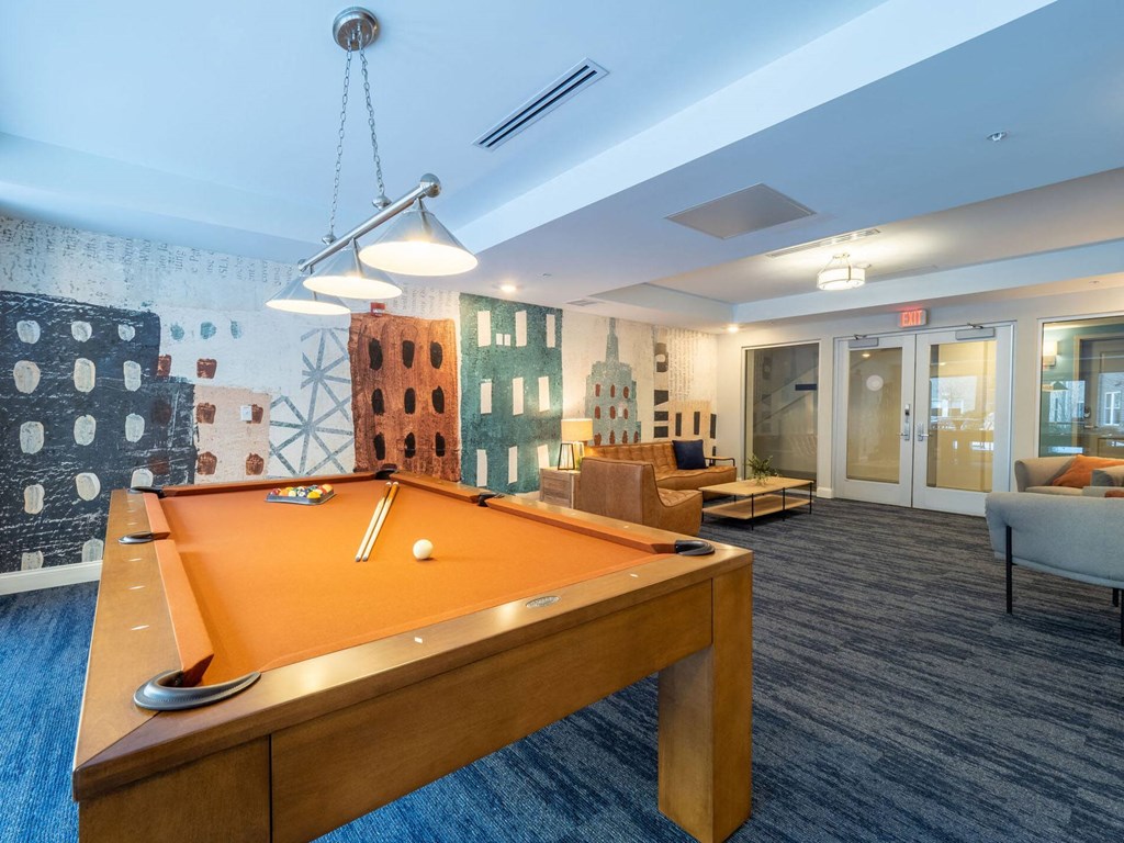 A stylish billiards room with a pool table and comfortable seating in the lounge