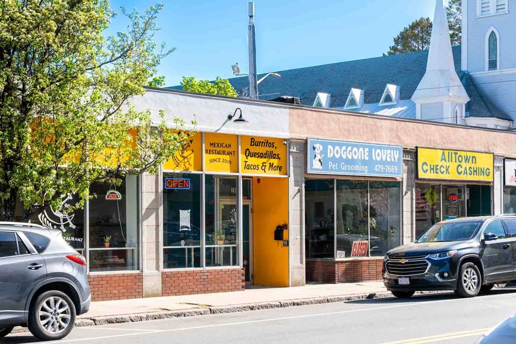 A yellow and white building with a sign that says