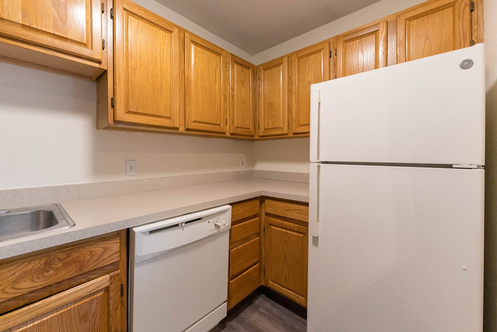 A kitchen with wooden cabinets and a white refrigerator.