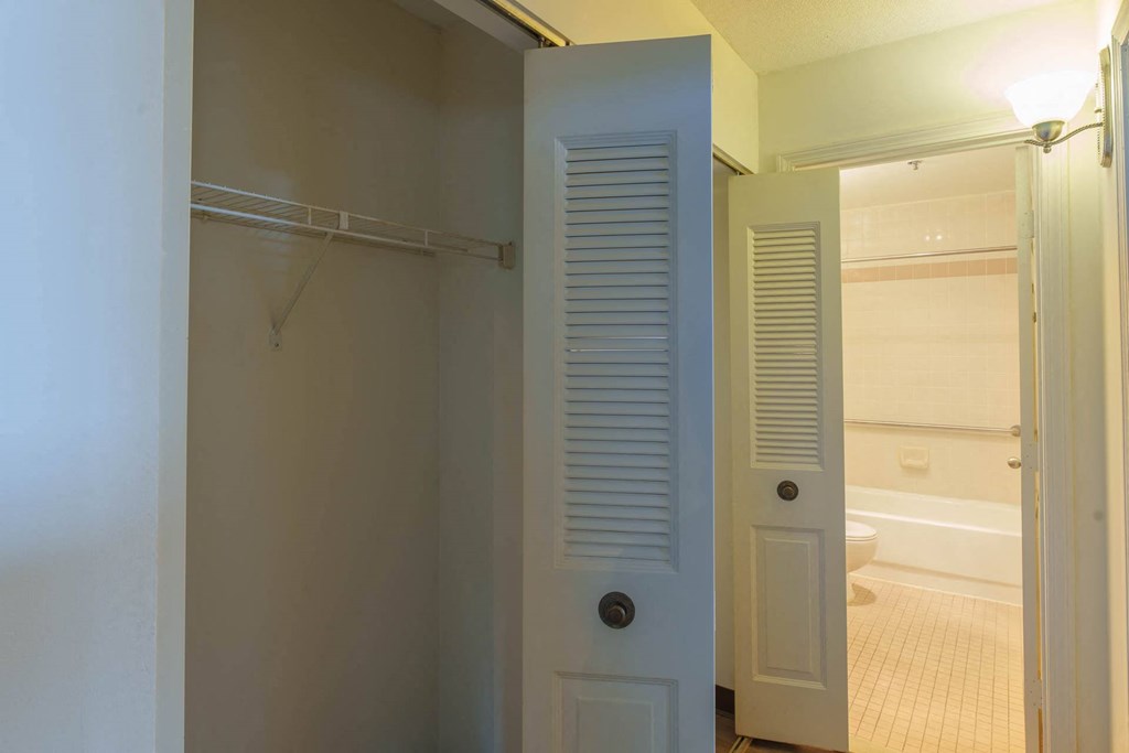 A white door with a black handle is open to a bathroom.