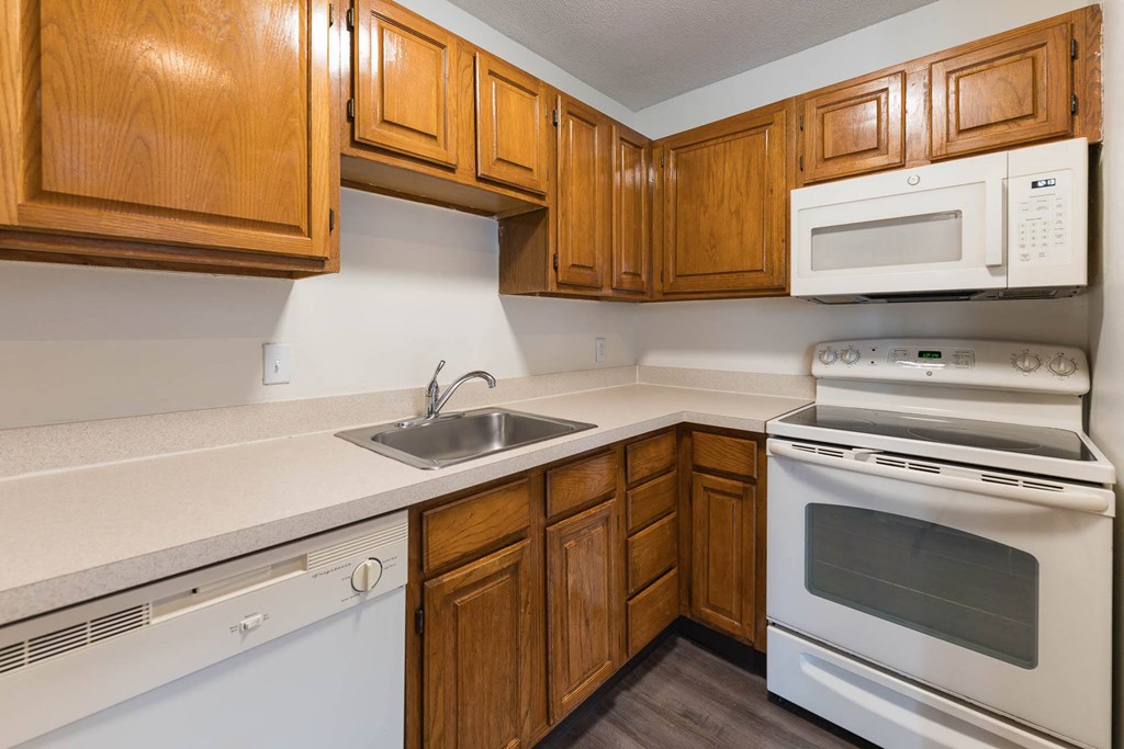A kitchen with wooden cabinets and white appliances.