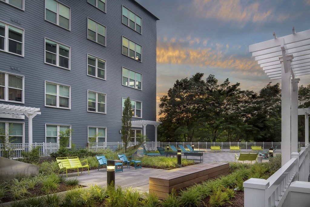 a courtyard with a large building and a sunset in the background