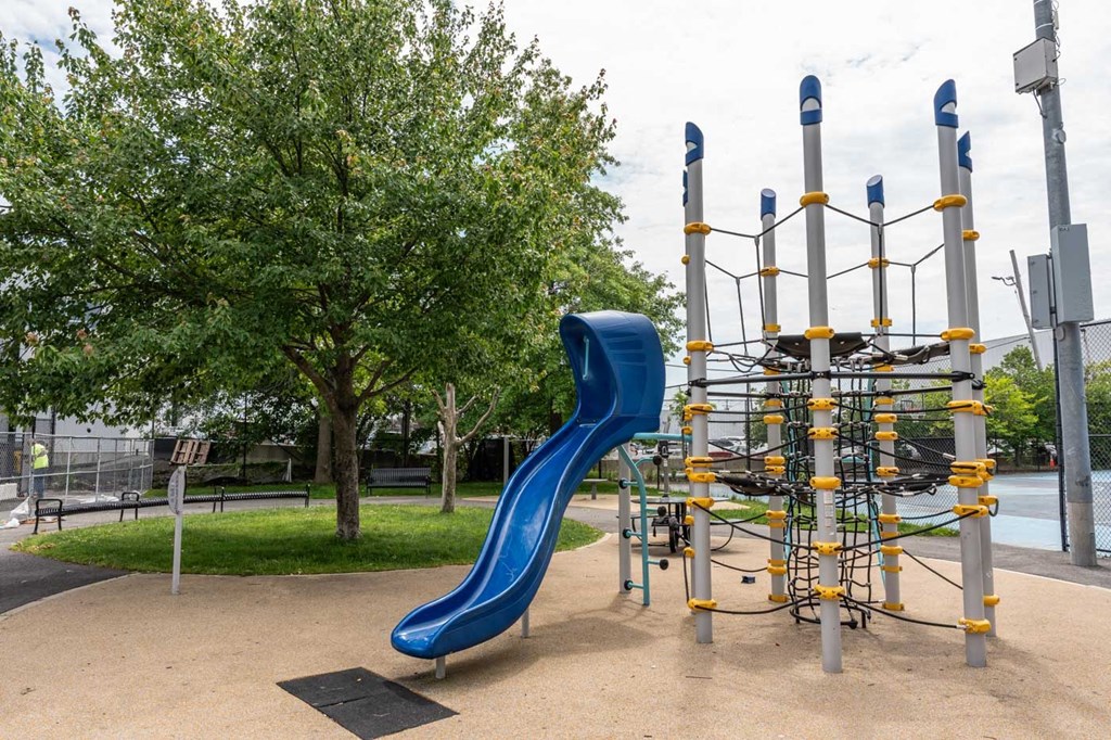 A playground with a blue slide and climbing structure.