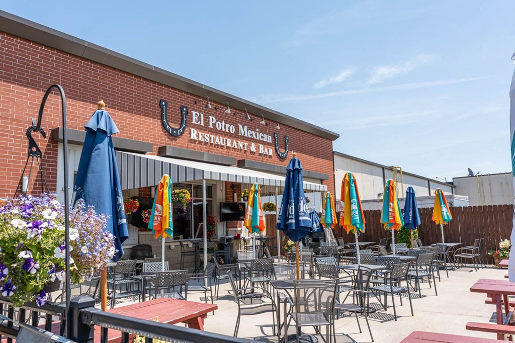 A Mexican restaurant and day club with tables and chairs set up outside.