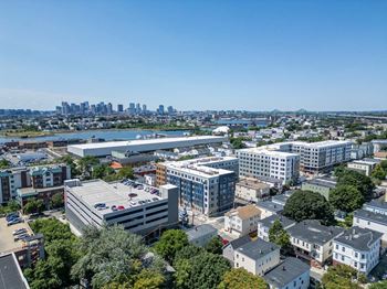 A cityscape with a mix of residential and commercial buildings, a river, and a distant city skyline.