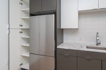 A kitchen with a refrigerator and a sink.