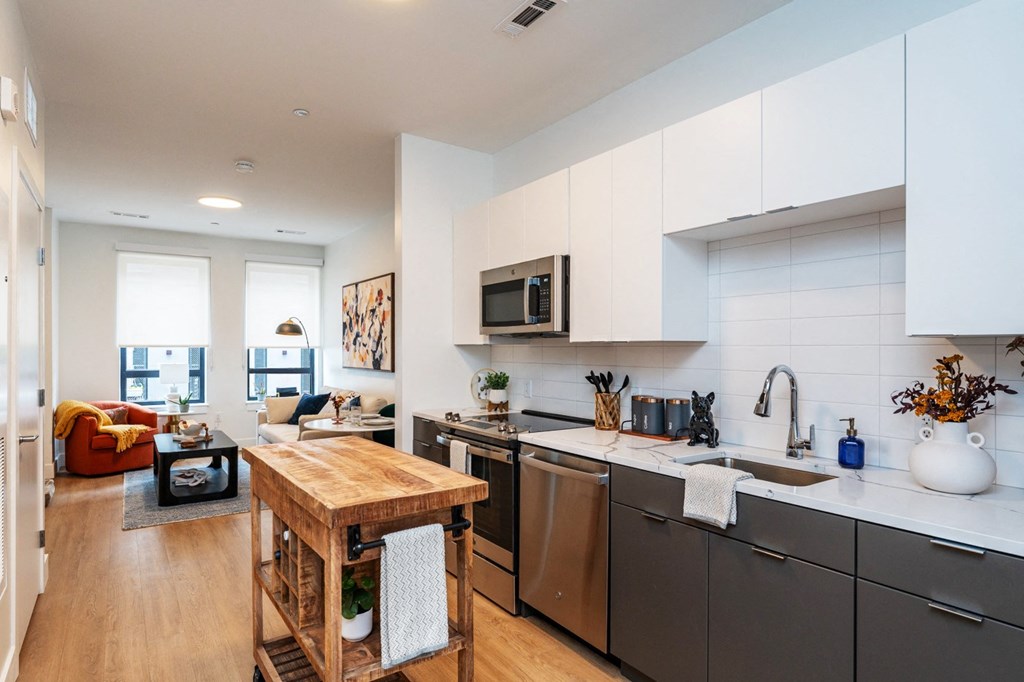 A modern kitchen with a wooden island and stainless steel appliances.