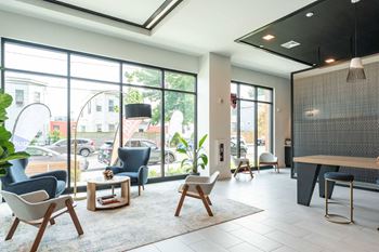 A modern living room with a large window overlooking a street.