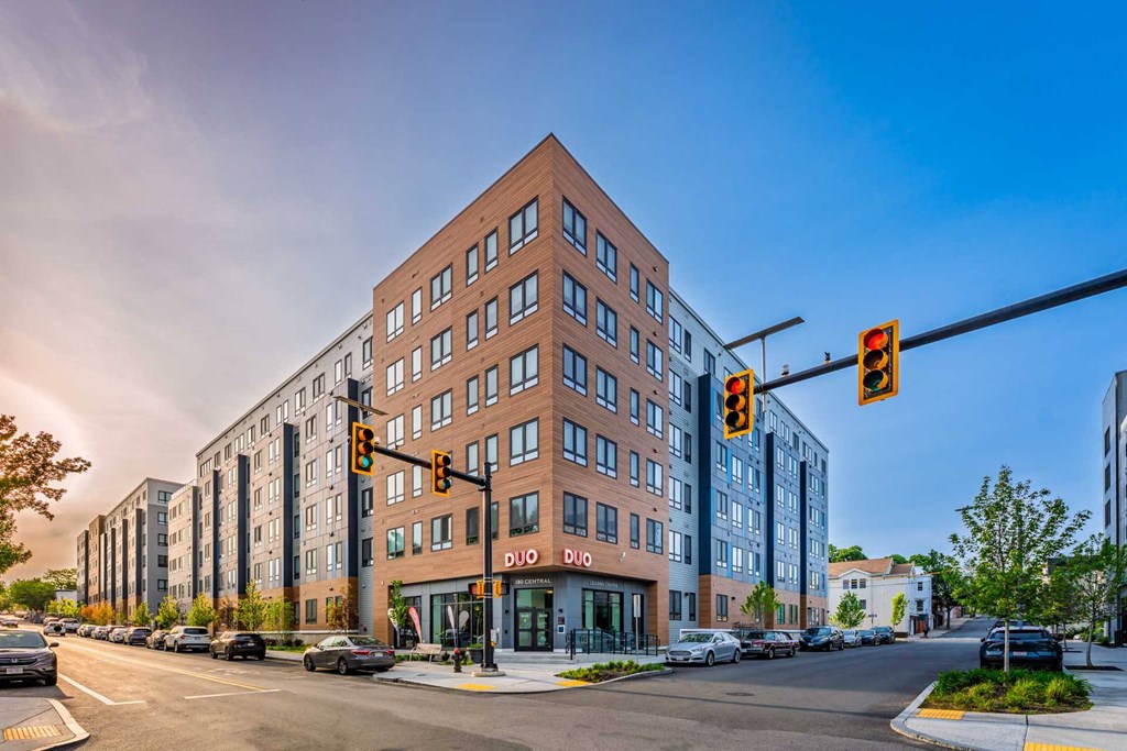 A street view of a multi-story building with a red brick facade and a sign that reads "DIO".