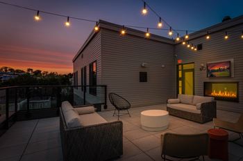 A patio with a fireplace and chairs.