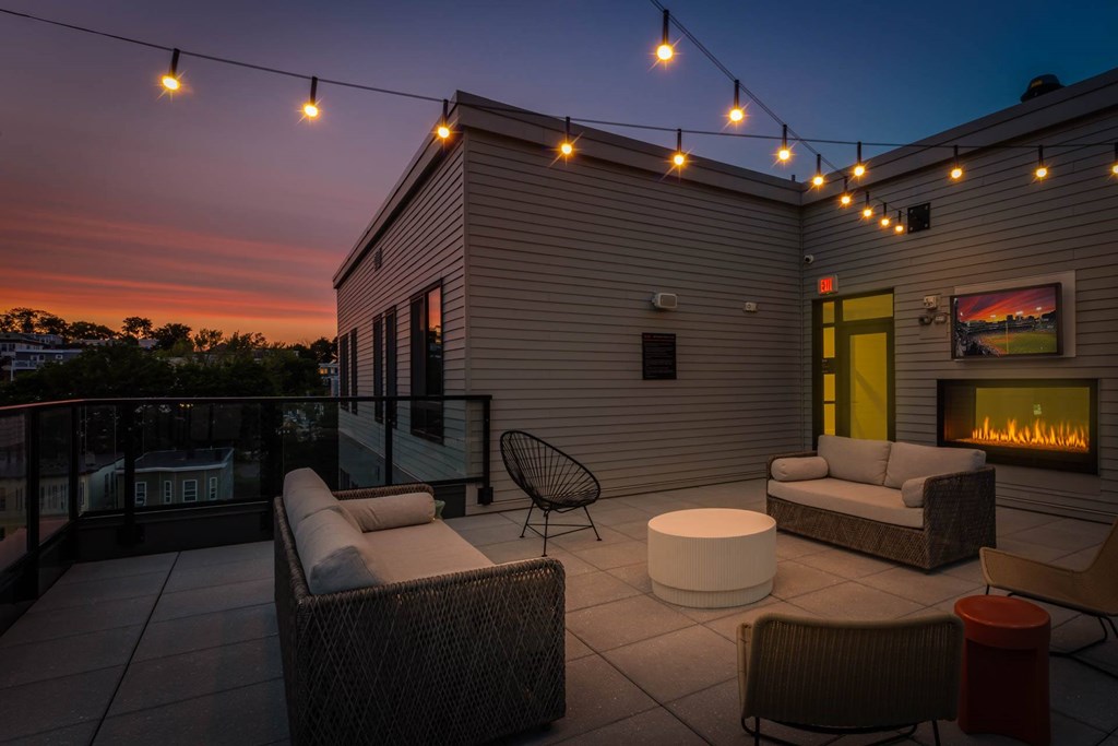 A patio with a fireplace and chairs.