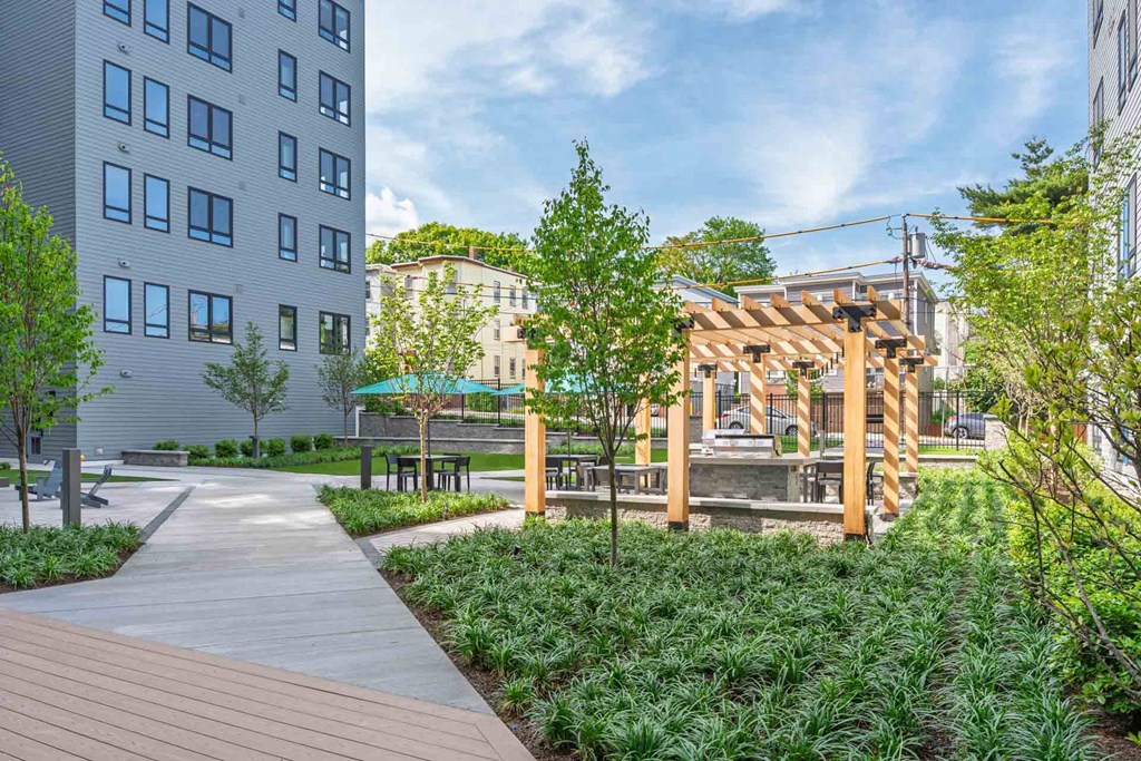 A wooden deck leads to a pavilion in a city park.