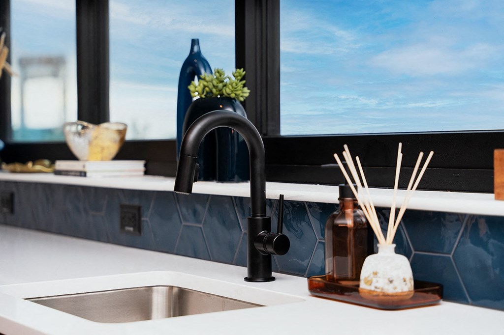 A modern kitchen with a black faucet and a window.