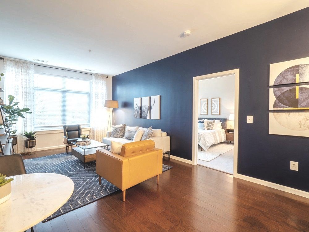 a living room with a blue accent wall and a yellow couch