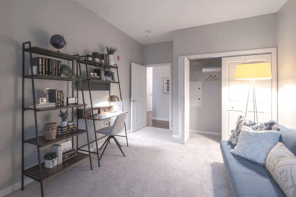 a home office with a desk and bookshelf in a living room