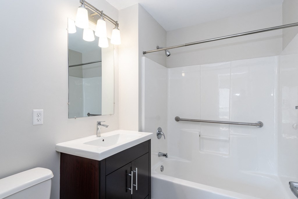 bathroom with tiled showers and bright vanity