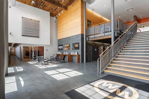 A large open space with a staircase and a table with chairs.