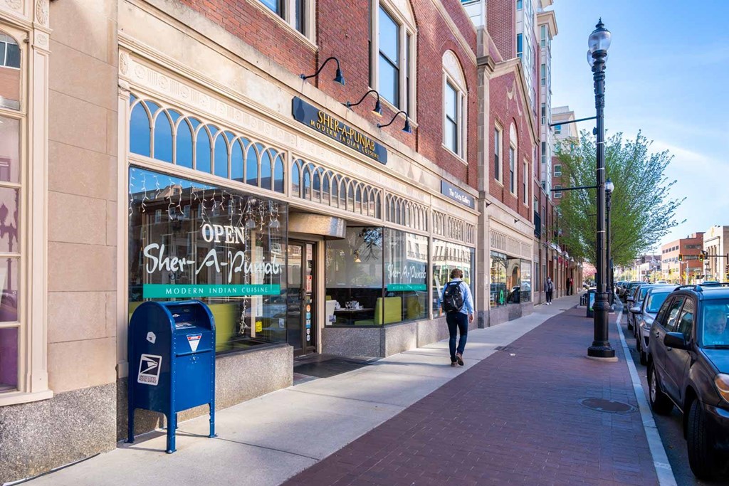 A street view with a person walking on the sidewalk.
