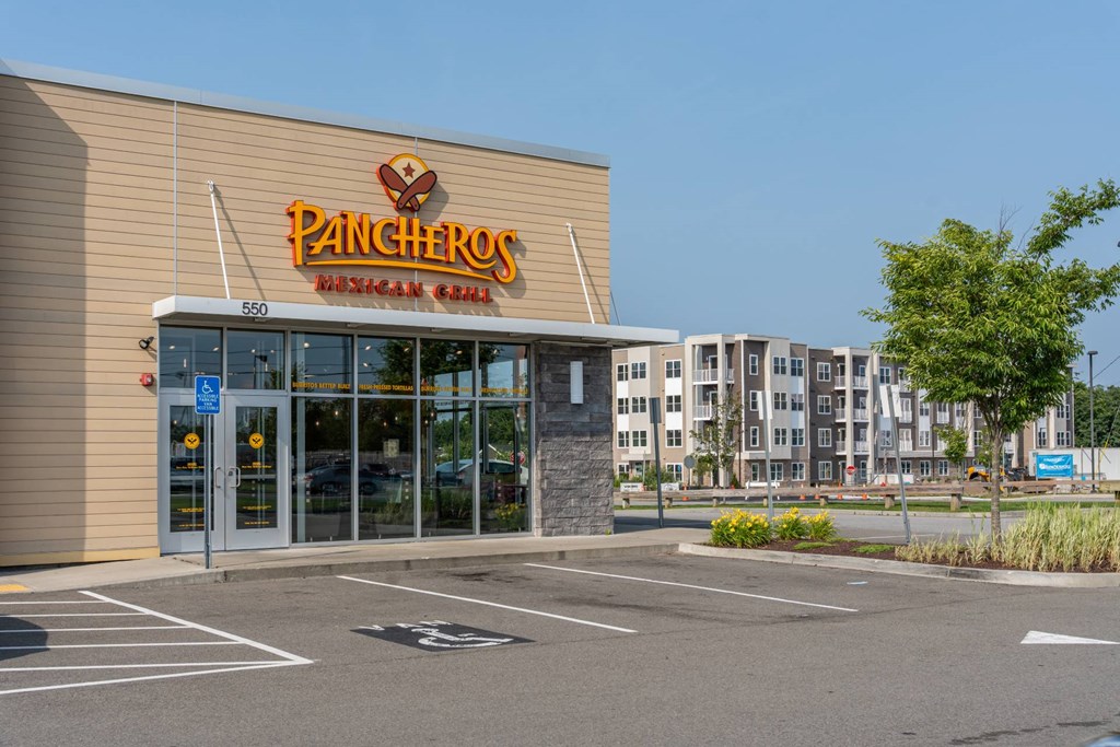 Pancheros Mexican Grill in the foreground with the Slade Farm apartment building visible across the parking area.