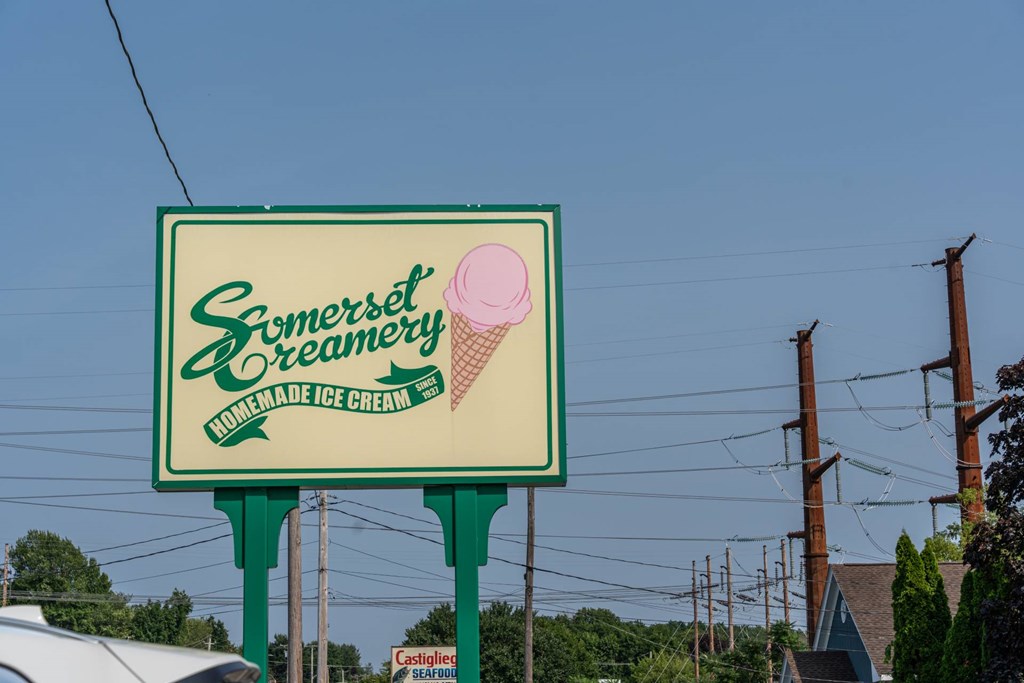 Somerset Creamery roadside sign with an illustrated pink ice-cream cone and green script lettering.
