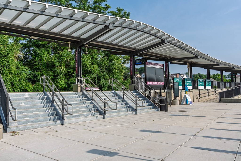 Wide granite steps and glass canopy at the entrance plaza of Fall River Depot commuter-rail station.