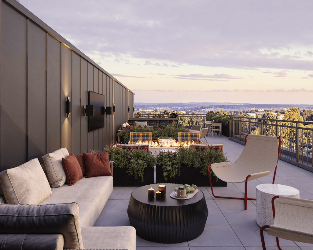 A patio with a couch, chairs, and a table with candles on it.
