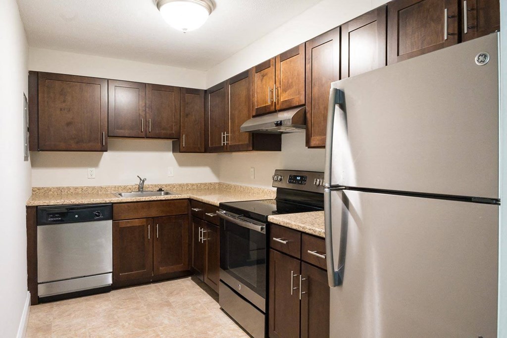 a kitchen with dark wood cabinets and stainless steel appliances