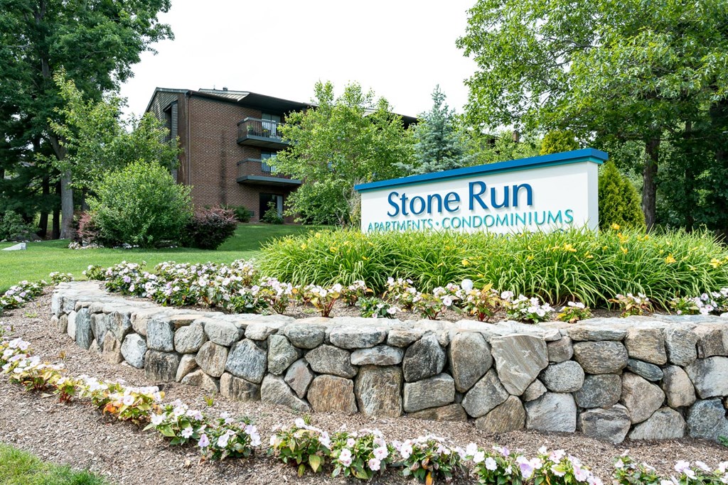 stone run entrance with flowers and plantings