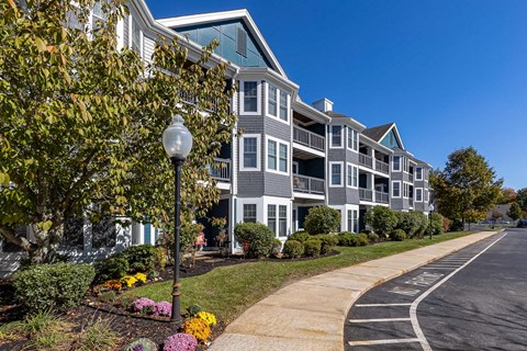 A street view of a residential area with apartment buildings and a sidewalk.