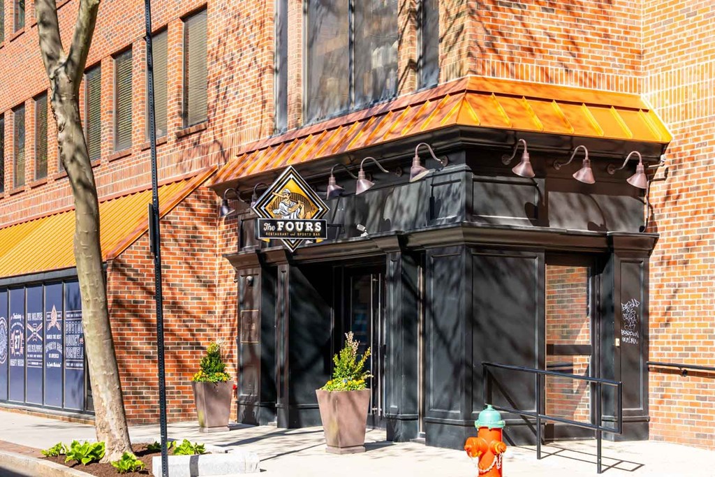 A building with a black awning and a fire hydrant in front of it.