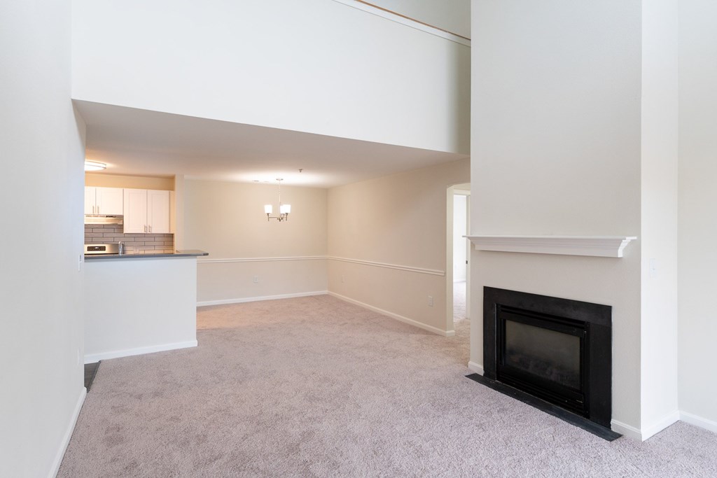 The Loft living room with a fireplace and grey carpet at Ledges Apartments in Weymouth.