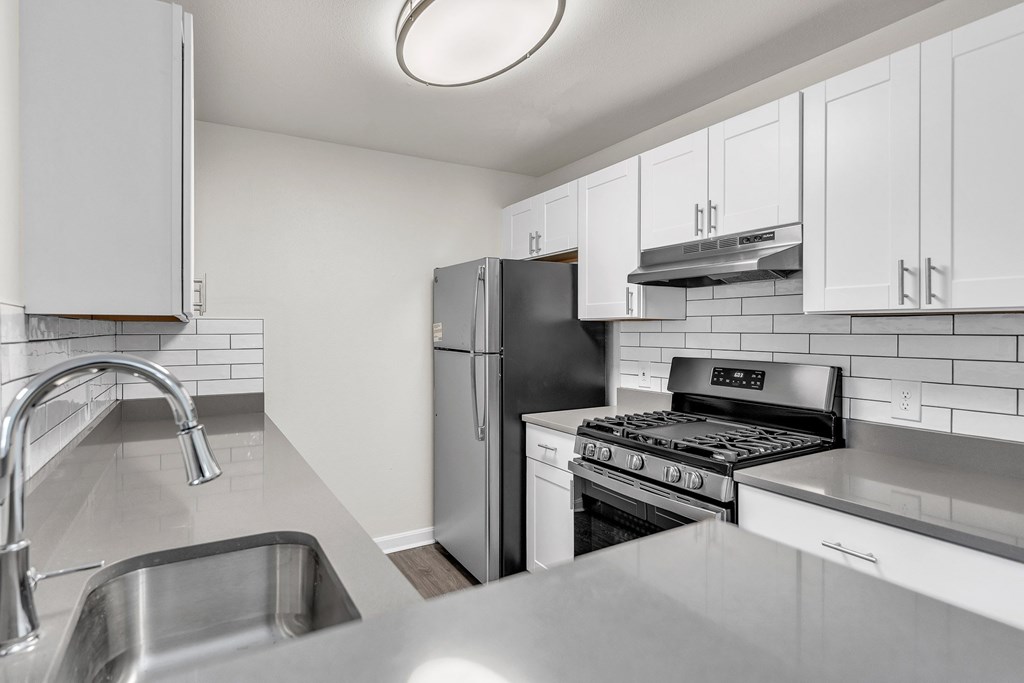 A kitchen with a refrigerator, stove, and oven in loft apartment at Ledges Apartments.