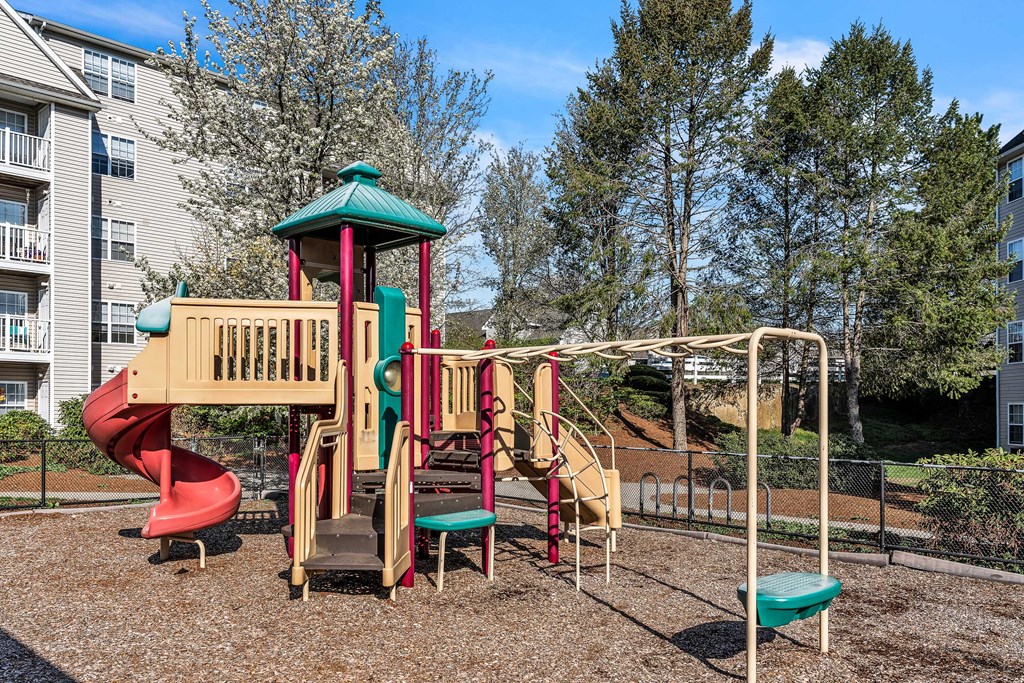 A playground with a red slide at the Ledges Apartments.