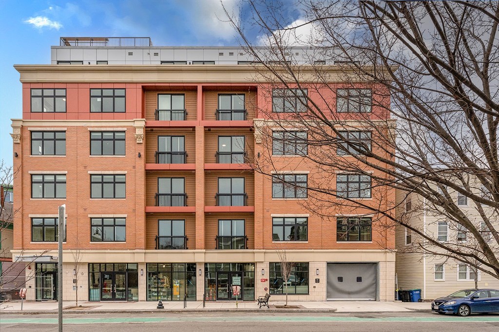 a large brick building with a parking garage in front of it a large brick building with a parking garage in front of it at Union 346, Somerville, MA