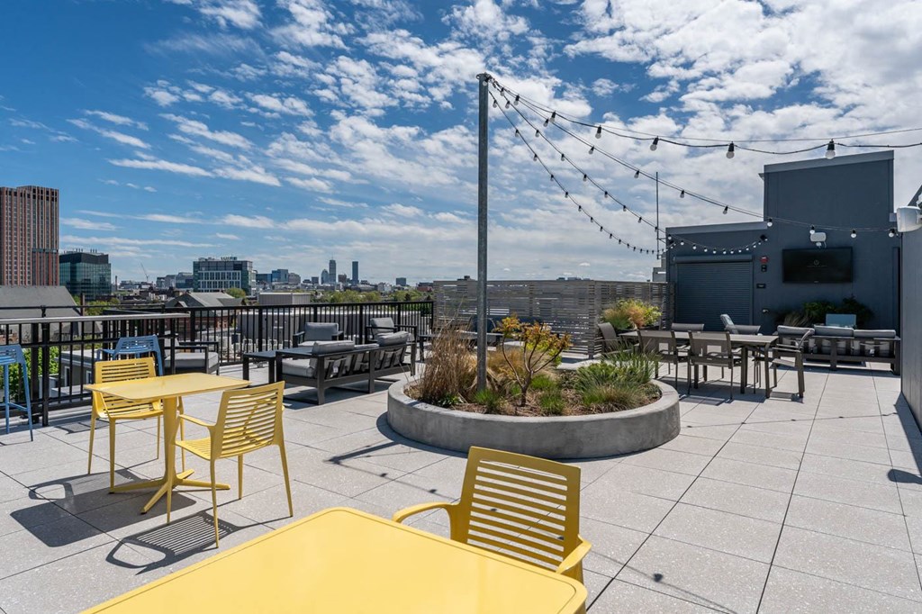 a rooftop patio with tables and chairs and a city in the background  at Union 346, Somerville, MA 02143